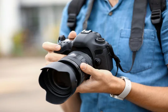 Person holding a DSLR camera